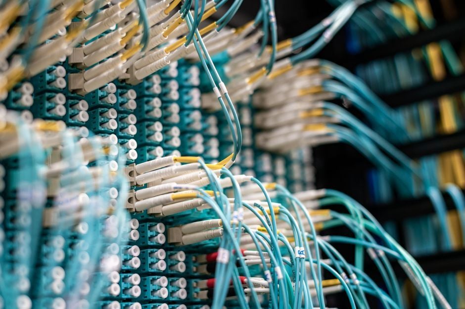 Cables de fibra óptica conectados a un panel de parcheo en un centro de datos